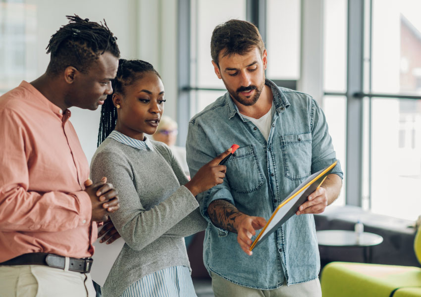 3 coworkers analyzing paperwork at the office